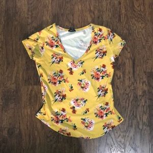 a yellow v-neck shirt with flowers.
